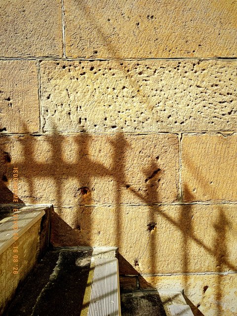 Railing shadow on weathered sandstone. Made with Isochrome, E Vivid 50.