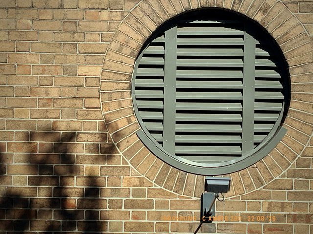 A round vent set into brickwork, late morning. Made with Isochrome, C Amber 200.